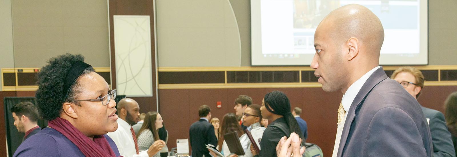 Pre-professional student speaks with lawyer at open house